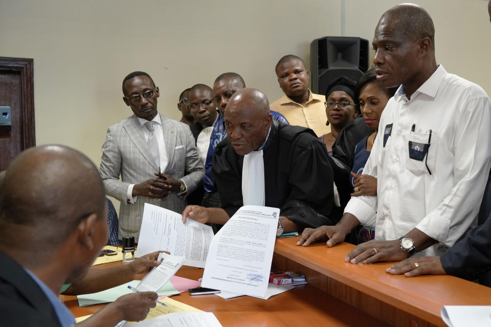 Accompanied by his wife and his lawyers, spurned Congo opposition candidate Martin Fayulu, right, petitions the constitutional court following his loss in the presidential elections in Kinshasa, Congo, Saturday Jan. 12, 2019. The ruling coalition of Congo's outgoing President Joseph Kabila has won a large majority of national assembly seats, the electoral commission announced Saturday, while the presidential election runner-up was poised to file a court challenge alleging fraud. (AP Photo/Jerome Delay)