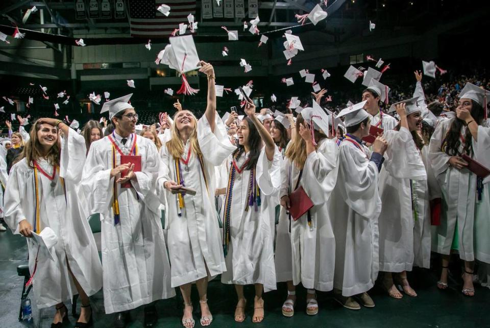 Graduates of Miami Beach Senior High toss their caps in the air after receiving their diplomas at the University of Miami’s Watsco Center on June 1, 2022.