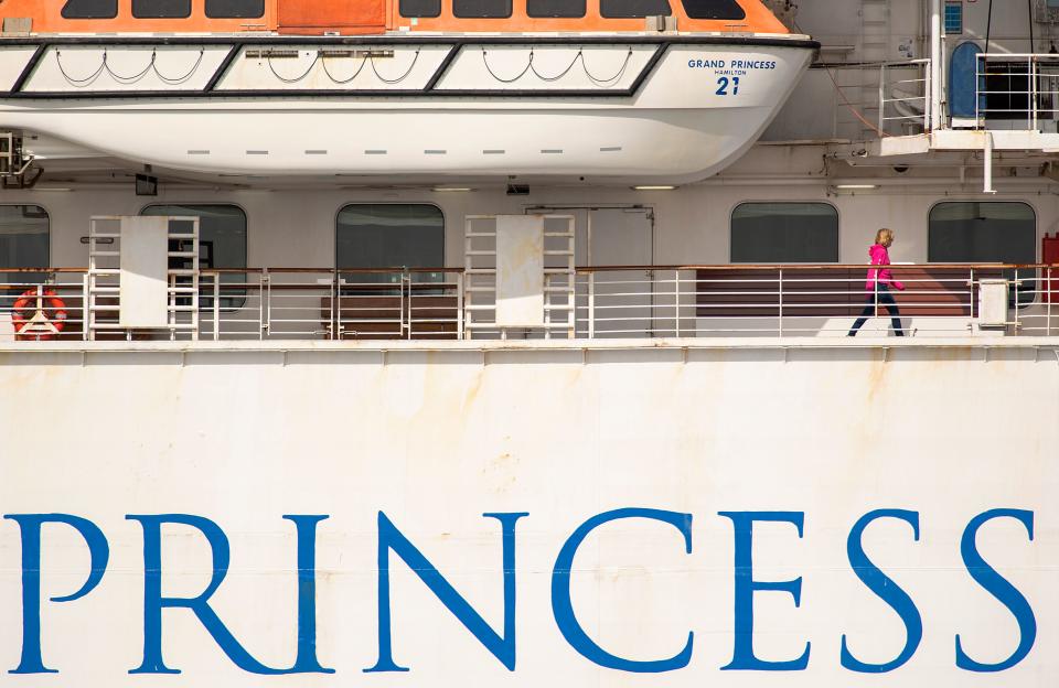 A passenger walks along the Grand Princess cruise ship, operated by Princess Cruises, as it maintains a holding pattern about 25 miles off the coast of San Francisco, California on March 8, 2020. - California prepared to disembark passengers from a virus-hit cruise ship as officials played down any risk to local communities.The Grand Princess, which has 21 novel coronavirus infections among the 3,500 people on board, is set to dock in Oakland Monday after four days held off the coast of nearby San Francisco. (Photo by Josh Edelson / AFP) (Photo by JOSH EDELSON/AFP via Getty Images)