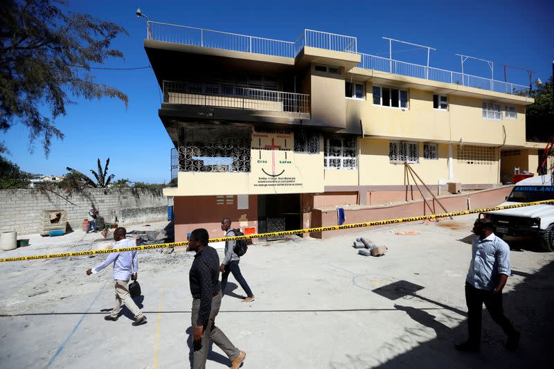 People walk outside an orphanage after part of it was destroyed in a fire, in Port-au-Prince