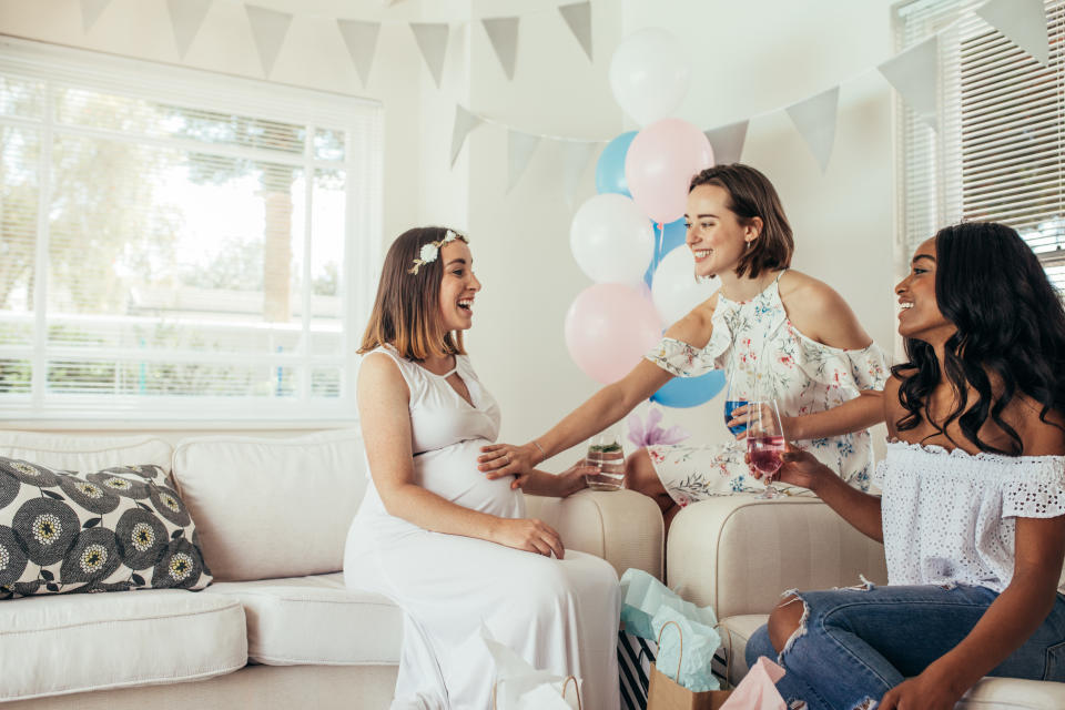 Three woman, one pregnant at a home baby shower