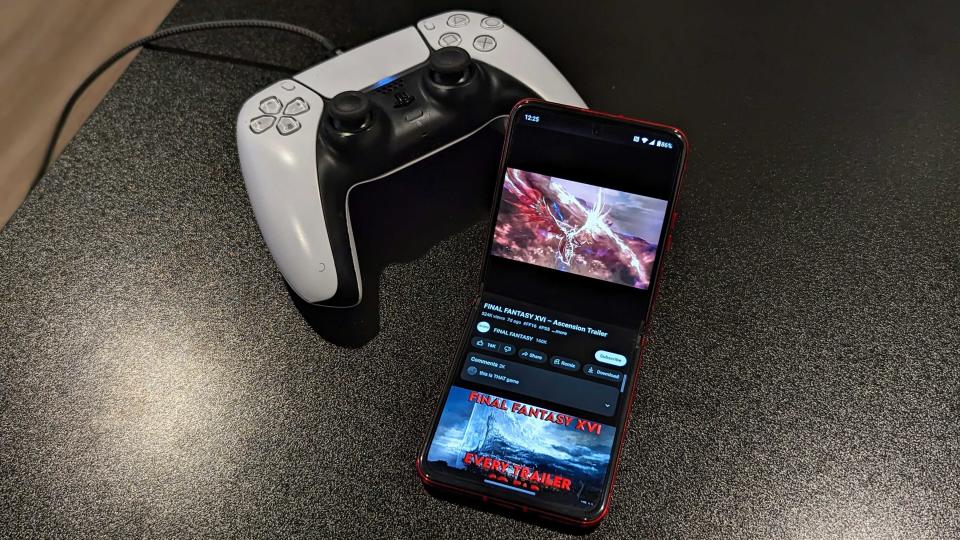 The Razr+ playing a YouTube video next to a DualSense controller