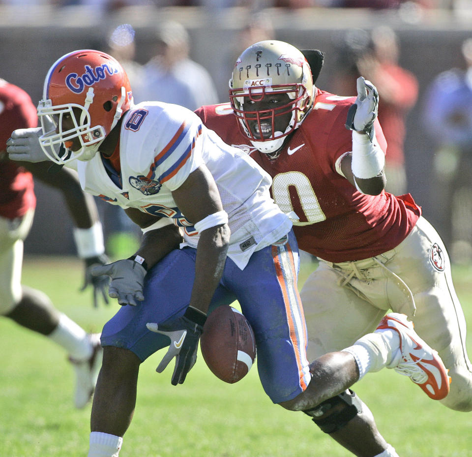 FILE - Florida receiver Percy Harvin, left, drops a second-quarter pass and he is hit by Florida State's Geno Hayes, right, during an NCAA college football game in Tallahasse, Fla., in this Saturday, Nov. 25, 2006, file photo. Hayes, a former NFL linebacker who starred at Florida State, has died. He was 33. The Tampa Bay Buccaneers on Tuesday, April 27, 2021, confirmed his death. He had liver disease and had been in hospice care. (AP Photo/Phil Coale, File)