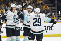 Seattle Kraken center Matty Beniers (10) celebrates with Jared McCann (19) Jordan Eberle (7), and Vince Dunn (29), after Beniers scored against the Nashville Predators during the third period of an NHL hockey game Saturday, March 25, 2023, in Nashville, Tenn. The Kraken won 7-2. (AP Photo/Mark Zaleski)