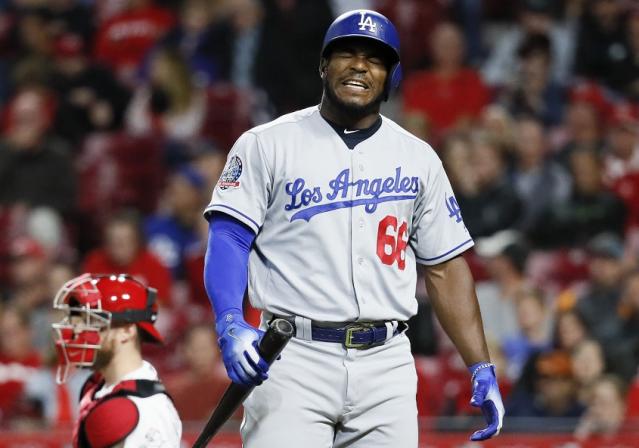 The Dodgers' Yasiel Puig writhes in pain after fouling off…