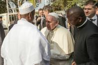 Pope Francis (C) is greeted by Central Mosque Nehedid Tidjani (L), upon his arrival in the PK5 neighborhood of Bangui, on November 30, 2015