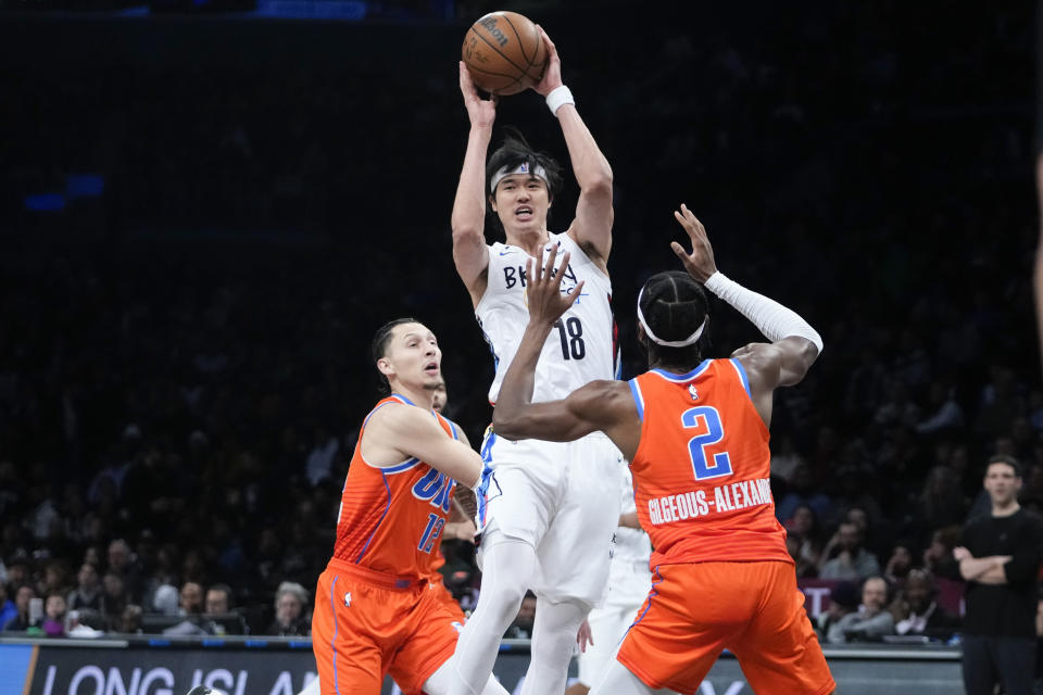 Brooklyn Nets' Yuta Watanabe (18), of Japan, passes the ball away from Oklahoma City Thunder's Shai Gilgeous-Alexander (2) and Lindy Waters III (12) during the first half of an NBA basketball game Sunday, Jan. 15, 2023, in New York. (AP Photo/Frank Franklin II)