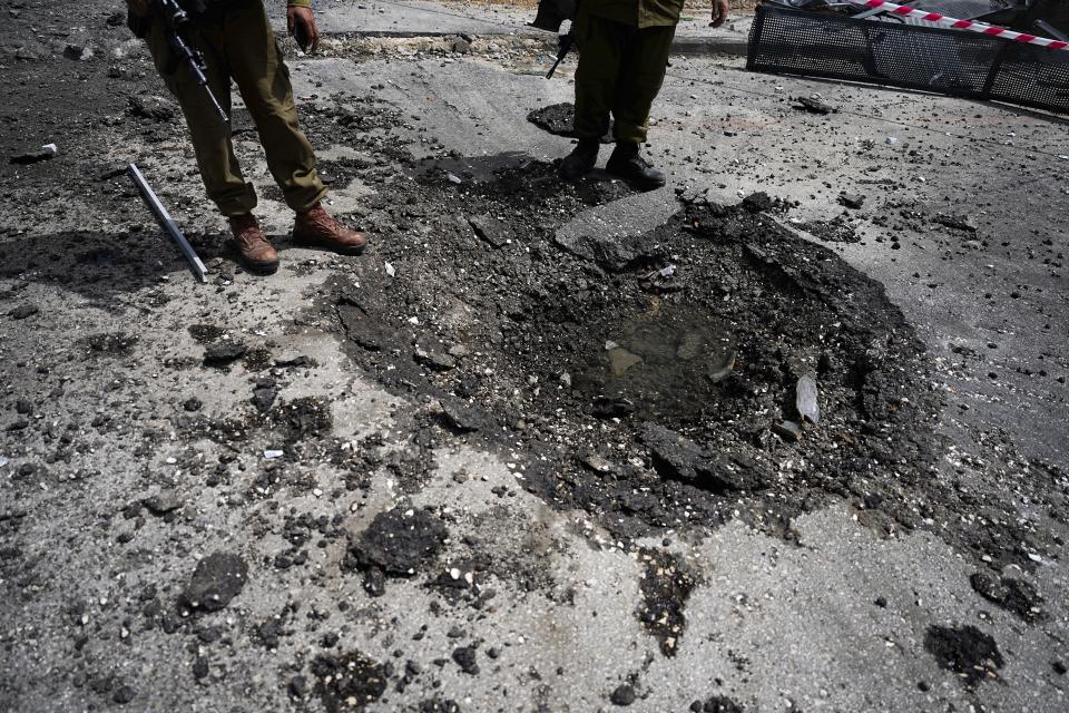 Israeli security forces examine the site hit by a rocket fired from Lebanon, in Kiryat Shmona, northern Israel, Wednesday, March 27, 2024. Israel Rescue Services said that one person was killed and two others lightly injured in a Hezbollah rocket attack on northern Israel. The man, aged 25, was killed from a fire that broke out at a factory in an industrial park in the northern city of Kiryat Shmona as a result of a direct hit. (AP Photo/Ariel Schalit)