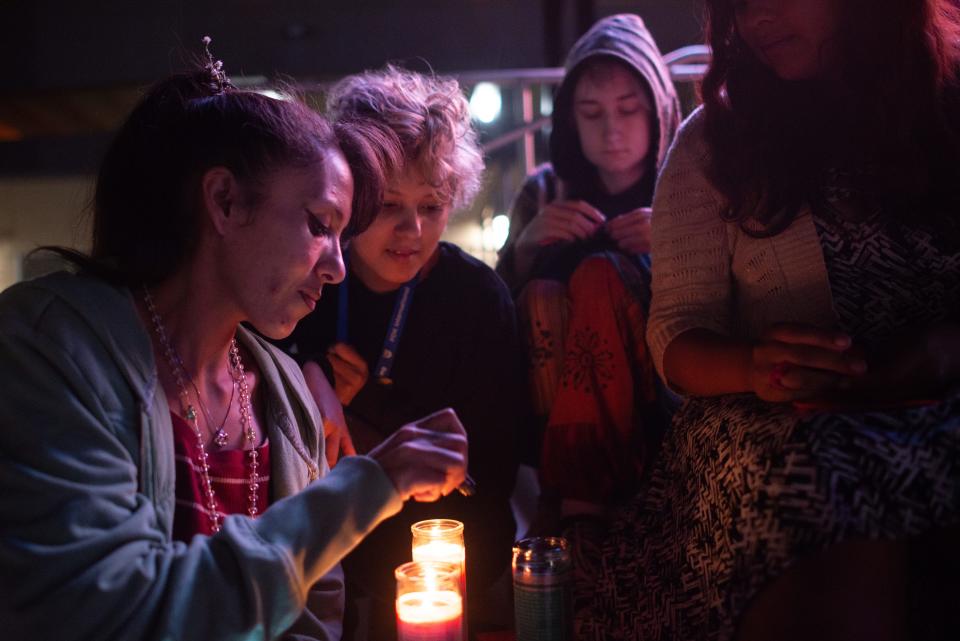 From left, Graciela Munoz, Vinny Rivera, Morgan Gray and Marieanna Rivera huddle around candles at Tuesday's candlelight vigil at Evergy Plaza. All knew one of the latest homicide victims, Victor Carlton. 