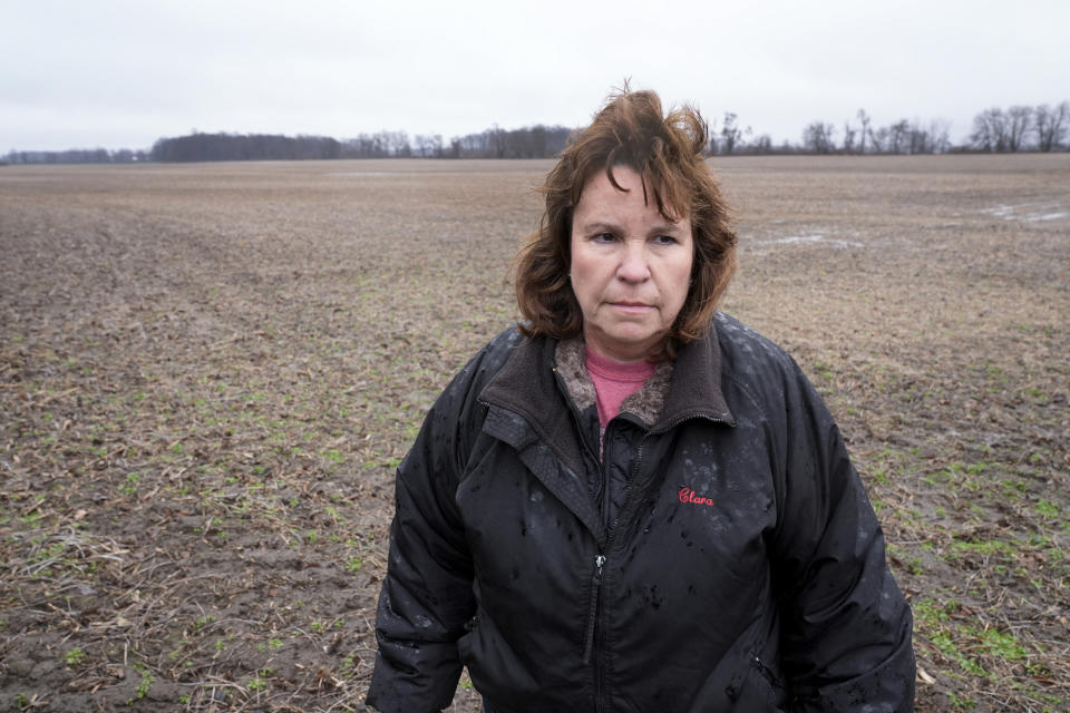 Clara Ostrander stands in her family's field in Maybee, Mich., Tuesday, Jan. 9, 2024. The family sought to lease some of the property for a solar energy project that would have paid enough to help them keep their land. Local opposition tanked the project and Ostrander now says there are neighbors she will never speak to again. (AP Photo/Paul Sancya)