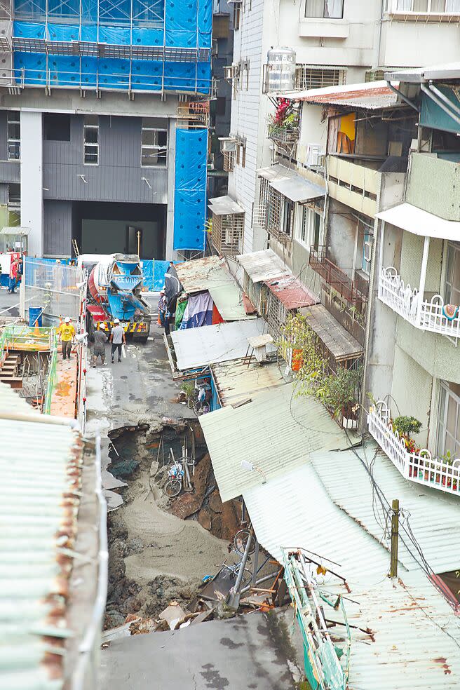 台北市信義區崇德街60巷13日驚傳地基嚴重坍塌，路面上出現巨大天坑，以致一旁住宅有倒塌危機，坑洞在緊急灌漿後，邊緣仍一度坍塌。（杜宜諳攝）