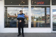 Security guard Austin MacMath wears a gun on his belt, Tuesday, April 19, 2022, while working outside Mary Mart, a marijuana store in Tacoma, Wash. A surge in robberies at licensed cannabis shops in Washington state is helping fuel a renewed push for federal banking reforms that would make the cash-dependent stores a less appealing target. (AP Photo/Ted S. Warren)