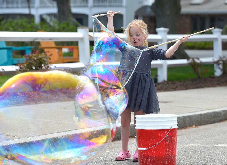 With a newly painted cat face, Nori Armstrong, 4, of Dedham, makes giant bubbles. Buckets were set out along Main Street to make the bubbles. Hyannis Open Streets was held along Main Street Sunday afternoon. Main Street was closed between Barnstable and Sea Streets for family friendly activities. To see more photos, go to www.capecodtimes.com/news/photo-galleries. Merrily Cassidy/Cape Cod Times