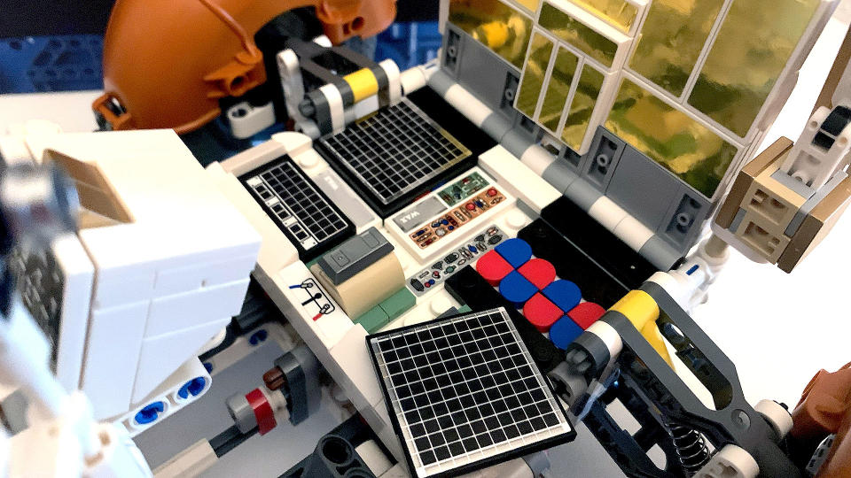 Hinged panels on the Lego Technic Apollo Lunar Roving Vehicle let you peek at the batteries that power the car. Lifting a brick cover (with sticker) reveals even more detail.