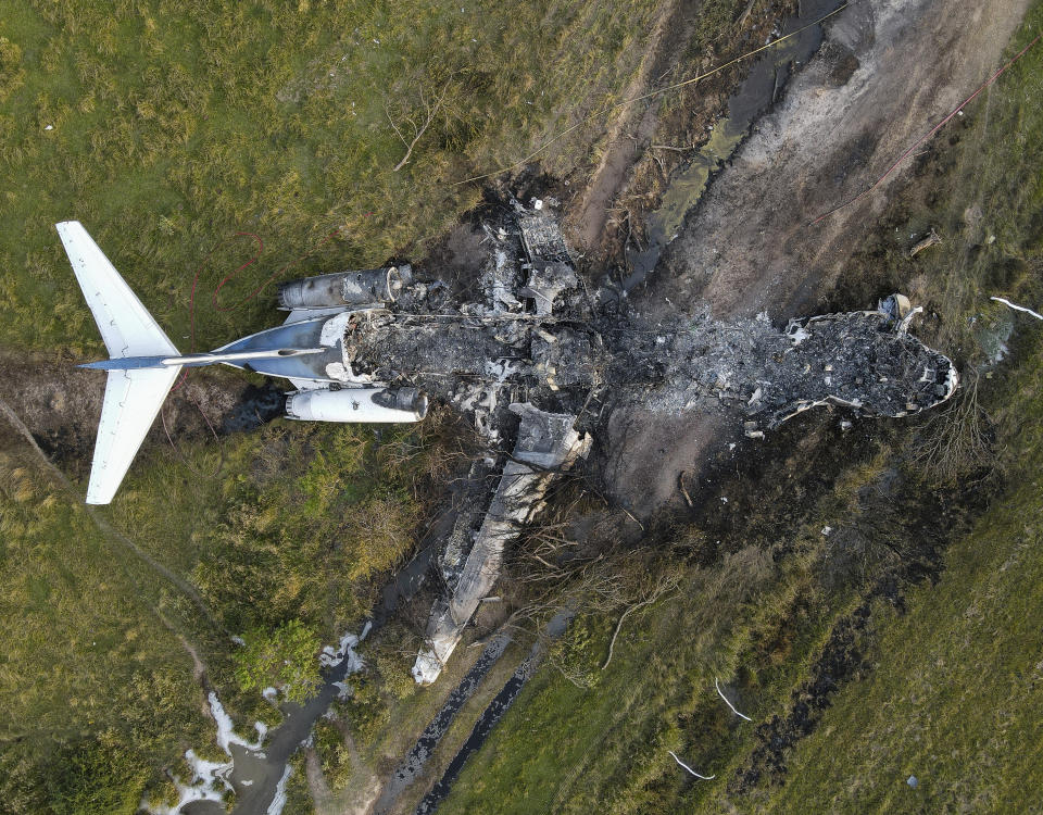 The remnants of an aircraft, which caught fire soon after a failed take-off attempt at Houston Executive Airport, are seen just north of Morton Road on Tuesday, Oct. 19, 2021, in Brookshire. Texas. (Godofredo A. Vásquez/Houston Chronicle via AP)
