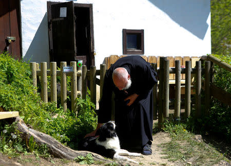 Hermit Stan Vanuytrecht of Belgium pets his dog outside the hermitage in Saalfelden, Austria, May 22, 2017. Picture taken May 22, 2017. REUTERS/Leonhard Foeger