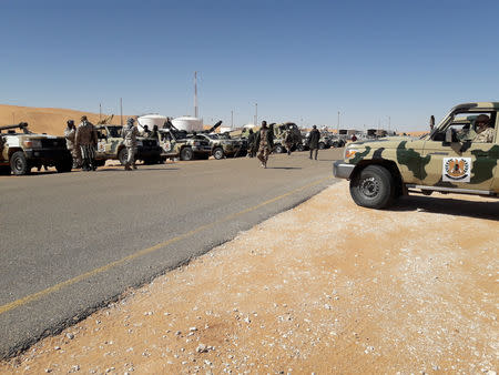 FILE PHOTO: Members of forces loyal to Libyan military commander Khalifa Haftar are seen with military vehicles near Libya's El Sharara oilfield in Obari,Libya, February 11, 2019. REUTERS/Stringer