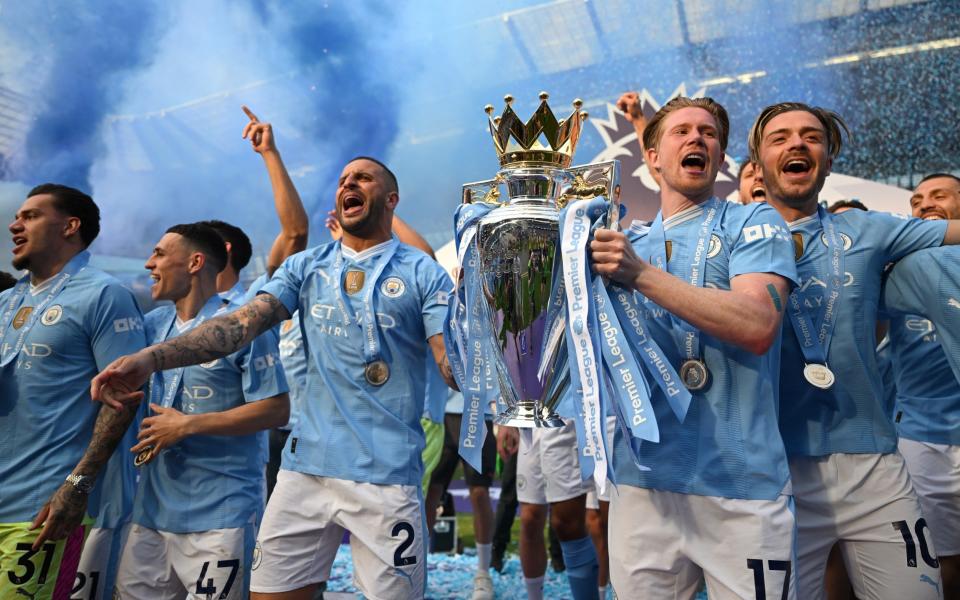 Kyle Walker and Kevin De Bruyne of Manchester City lift the Premier League Trophy after their team's victory over West Ham United at Etihad Stadium, May 19, 2024