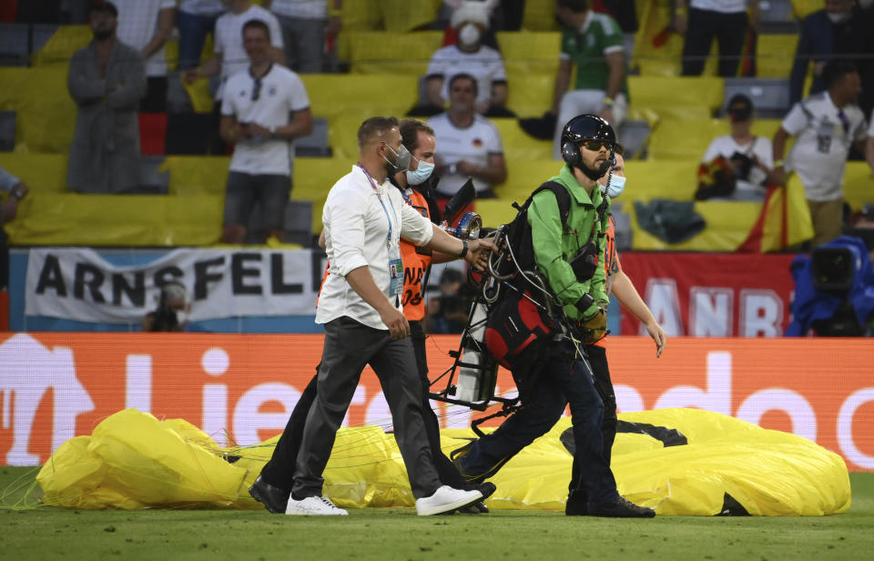 Paraglider walks on the pitch prior the start of the Euro 2020 soccer championship group F match between Germany and France at the Allianz Arena stadium in Munich, Tuesday, June 15, 2021. (Franck Fife/Pool via AP)