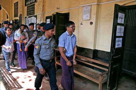 Detained Reuters journalist Wa Lone and Kyaw Soe Oo are escorted by police while arriving for a court hearing after lunch break in Yangon, Myanmar February 14, 2018. REUTERS/Stringer