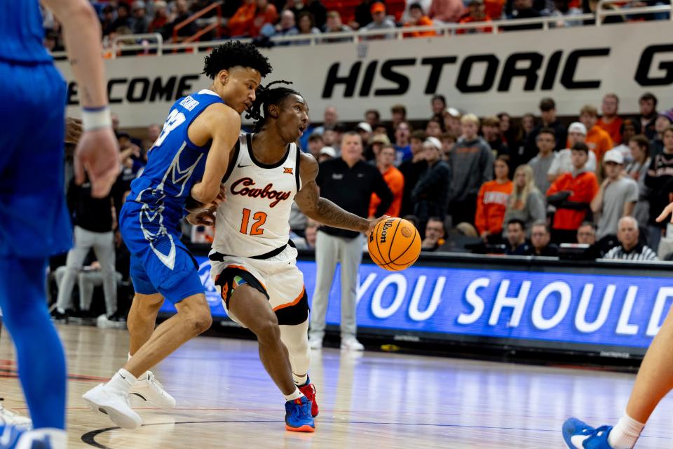 Oklahoma State guard Javon Small (12) runs into Creighton guard Trey Alexander (23) in the second half of an NCAA college basketball game, Thursday, Nov. 30, 2023, in Stillwater, Okla. (AP Photo/Mitch Alcala)