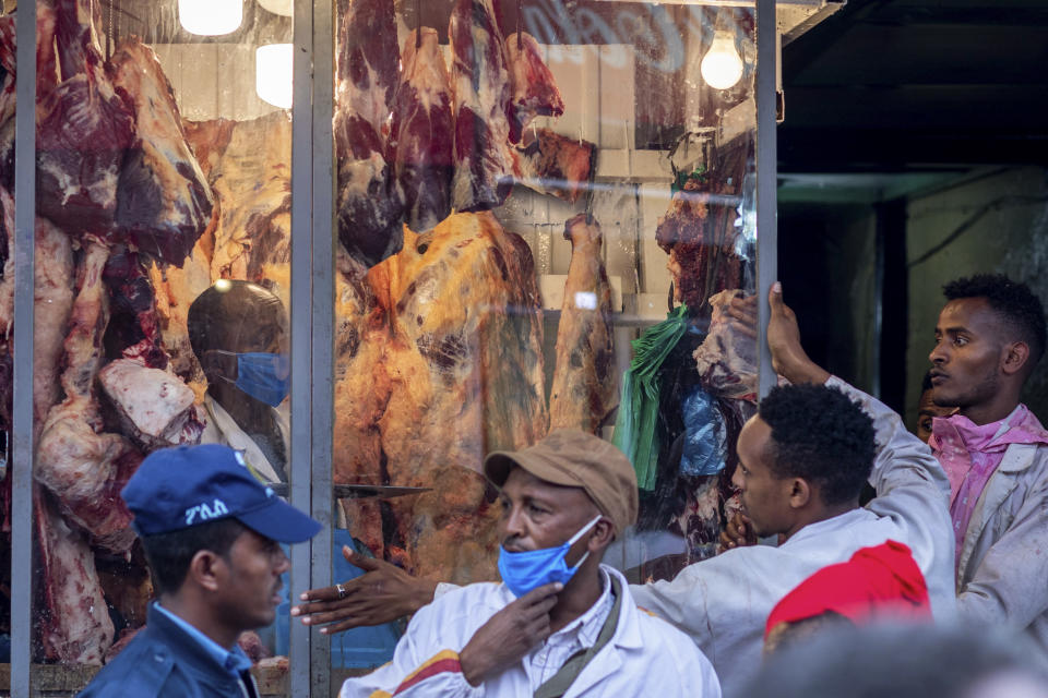 Butchers and others wear masks to curb the spread of the new coronavirus, as they sell lamb, beef, and goat meat for Orthodox Easter, at a butchers shop in Addis Ababa, Ethiopia Sunday, April 19, 2020. For Orthodox Christians, this is normally a time of reflection and communal mourning followed by joyful release, of centuries-old ceremonies steeped in symbolism and tradition. But this year, Easter — by far the most significant religious holiday for the world's roughly 300 million Orthodox —has essentially been canceled. (AP Photo/Mulugeta Ayene)