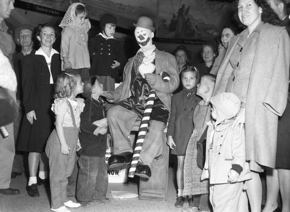 Dec. 5, 1945: Teamed with Santa Claus again to provide merry moments for struggling Christmas shoppers and the youngsters who accompany them is Paul Jung, circus clown. He is going through one of his many acts for a typical group of children at Leonard Brothers department store.