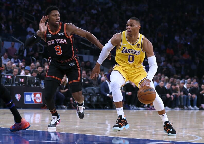 Los Angeles Lakers guard Russell Westbrook (0) drives against New York Knicks guard RJ Barrett (9) during the first half of an NBA basketball game Tuesday, Nov. 23, 2021, in New York. (AP Photo/Jim McIsaac)