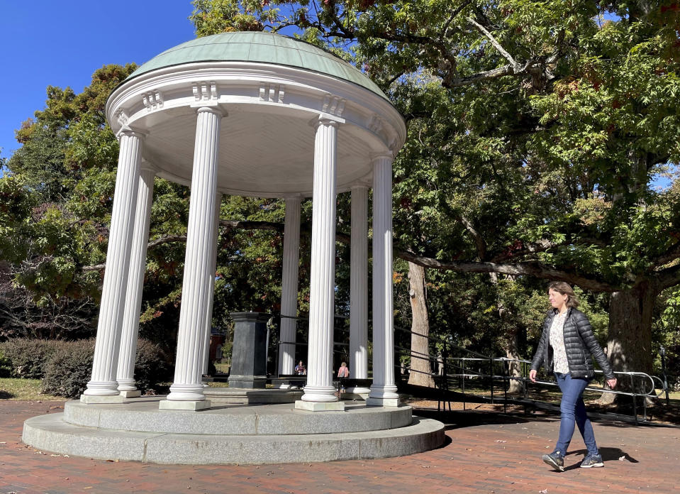 A student walks by the Old Well at the University of North Carolina at Chapel Hill, a rotunda and campus landmark at the southern end of McCorkle Place, on Monday, Oct. 24, 2022. A Confederate statue known as Silent Sam statue once stood in the plaza before it was toppled by protesters in 2018. (AP Photo/Hannah Schoenbaum)