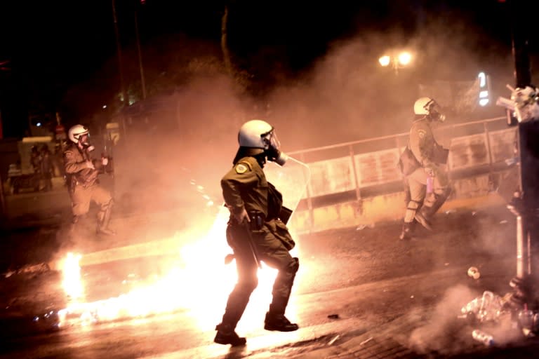 Riot police chase after protesters throwing petrol bombs in central Athens during an anti-austerity protest on July 15, 2015