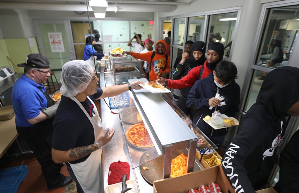 Cafeteria worker Alex Espada, left, serves slices from a trio of pizza options to students during their lunch period at Wilson Magnet High School in Rochester Wednesday, June 8, 2022. 