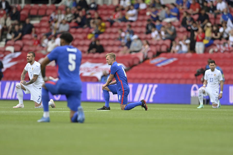 England's and Romania's players take a knee before the international friendly soccer match between England and Romania in Middlesbrough, England, Sunday, June 6, 2021. (Paul Ellis, Pool via AP)