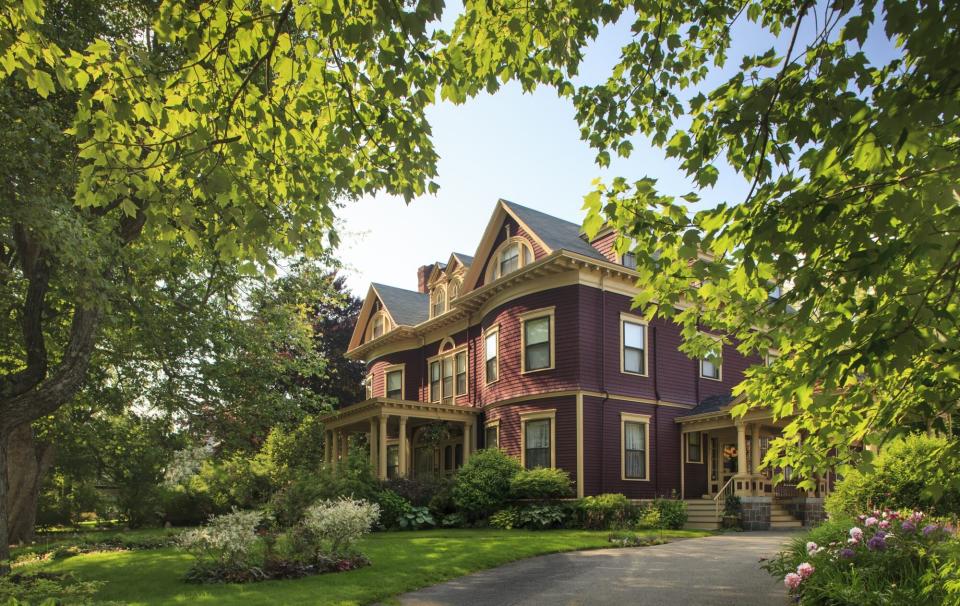 victorian home with trees in front yard