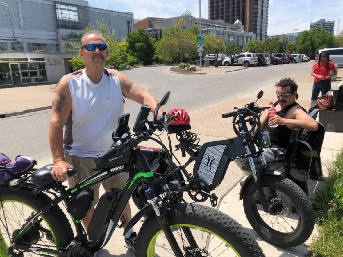 Robert Morin, left and Rick Racine, right, are cyclists who ride together. Morin says for a portion of Riverside Drive, there is no cycling lane, meaning cyclists like him have to ride on the road with drivers. (TJ Dhir/CBC - image credit)