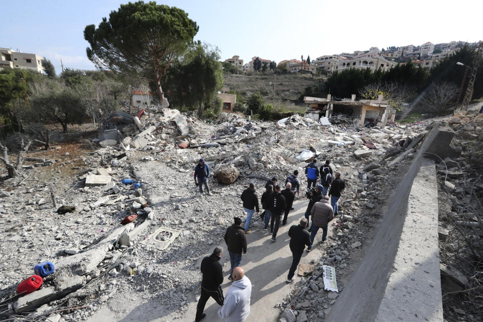 Lebanese citizens gather in front of a house that was destroyed by an Israeli airstrike Tuesday night, in Bint Jbeil, South Lebanon, Wednesday, Dec. 27, 2023. One Hezbollah fighter and two civilians, a newlywed couple, were killed in an overnight Israeli strike on a family-owned residential building in the town of Bint Jbeil, local residents and state media said Wednesday. (AP Photo/Mohammed Zaatari)