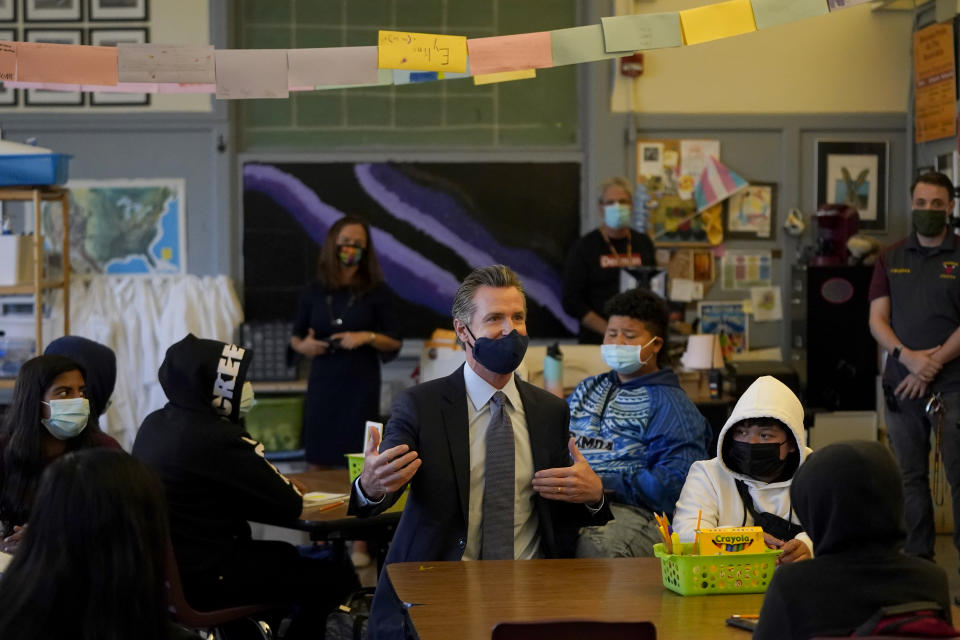 Gov. Gavin Newsom sitting with students in a classroom.