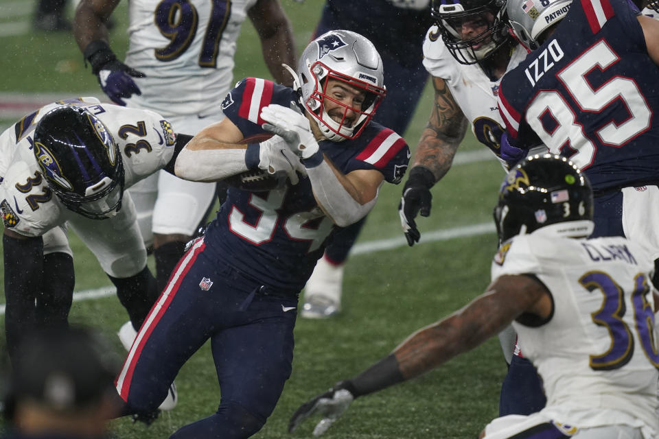 New England Patriots running back Rex Burkhead, center, carries the ball as Baltimore Ravens safeties DeShon Elliott (32) and Chuck Clark (36) give chase in the first half of an NFL football game, Sunday, Nov. 15, 2020, in Foxborough, Mass. (AP Photo/Elise Amendola)