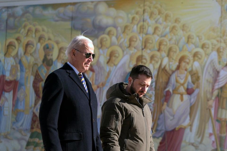 US President Joe Biden, left, walks with Ukrainian President Volodymyr Zelenskyy in front of a colorful mural of angels at St. Michaels Golden-Domed Cathedral during an unannounced visit, in Kyiv, Ukraine, Monday, Feb. 20, 2023