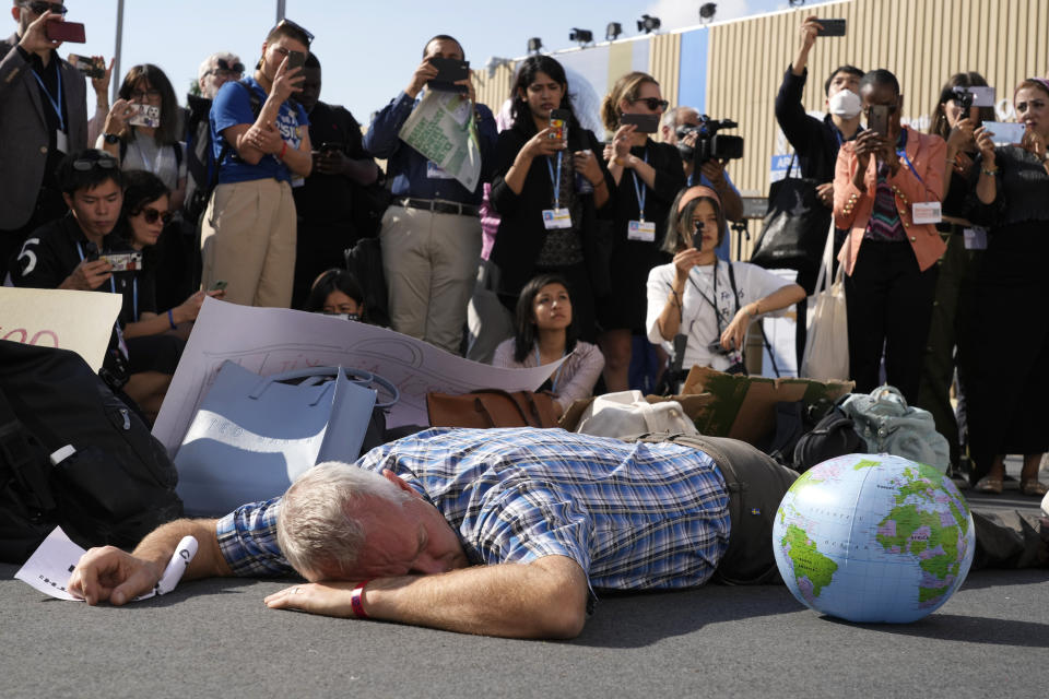 A demonstrator participates in a "die-in" advocating for the 1.5 degree warming goal to survive at the COP27 U.N. Climate Summit, Wednesday, Nov. 16, 2022, in Sharm el-Sheikh, Egypt. (AP Photo/Peter Dejong)