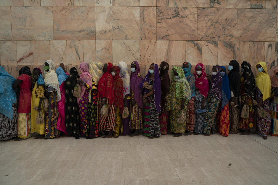 Wearing protective masks, women stand in line to enter the Grand Mosque of Touba as they take part in the celebrations of the Grand Magal of Touba, Senegal, Monday, Oct. 5, 2020. Despite the coronavirus pandemic, thousands of people from the Mouride Brotherhood, an order of Sufi Islam, are gathering for the annual religious pilgrimage to celebrate the life and teachings of Cheikh Amadou Bamba, the founder of the brotherhood. (AP Photo/Leo Correa)