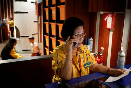 Soliano Paulina, 75, makes a call at the counter at Smaland, a play area for children at Ikea, in Singapore December 14, 2018. REUTERS/Edgar Su/Files