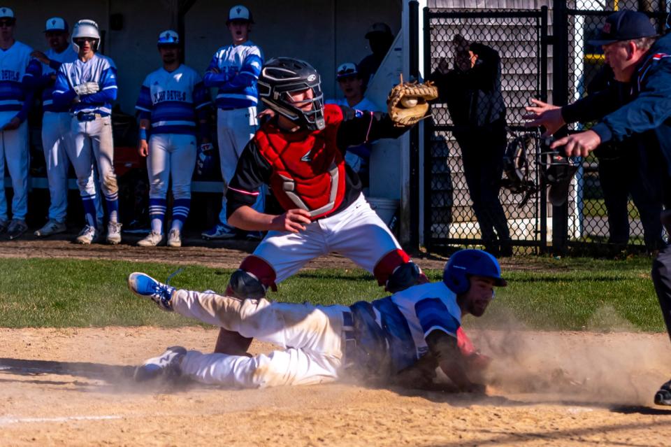 Old Rochester's Alec Marsden shows the umpire the ball to no avail, as Fairhaven's Cam Gordon slides in safely.