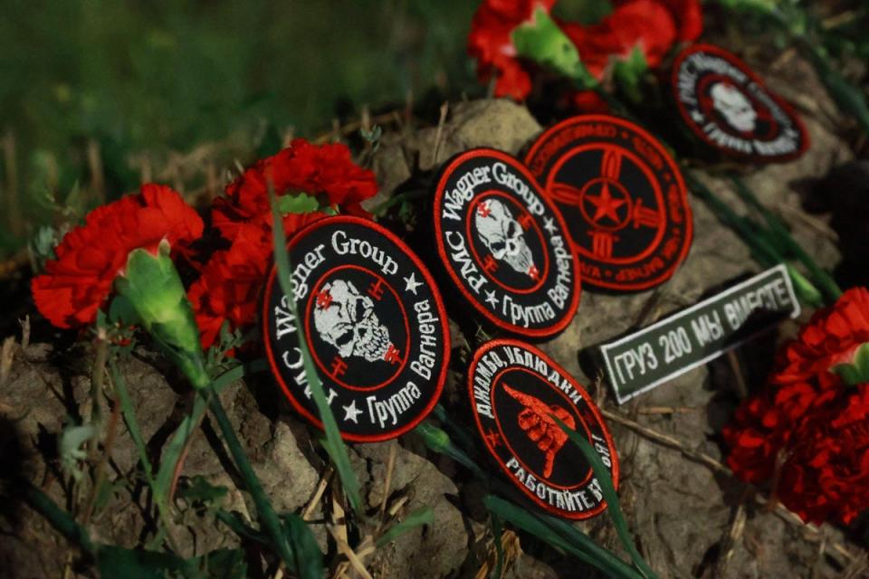 Flowers and patches bearing the logo of private mercenary group Wagner are seen at the makeshift memorial in front of the PMC Wagner Centre in St Petersburg (AFP via Getty Images)