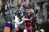 Rescuers pull out a woman from a collapsed building 87 hours after the earthquake in Kahramanmaras, southern Turkey, Thursday, Feb. 9, 2023. Thousands who lost their homes in a catastrophic earthquake huddled around campfires and clamored for food and water in the bitter cold, three days after the temblor and series of aftershocks hit Turkey and Syria. ( IHA via AP)