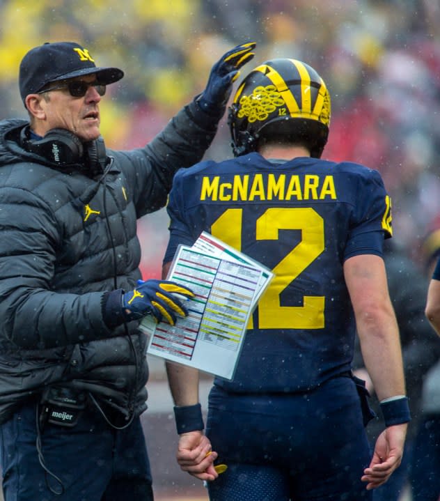 FILE – Michigan head coach Jim Harbaugh pats the helmet of quarterback Cade McNamara (12) after a touchdown in the fourth quarter of an NCAA college football game against Ohio State in Ann Arbor, Mich., Saturday, Nov. 27, 2021. Michigan won 42-27. (AP Photo/Tony Ding, File)