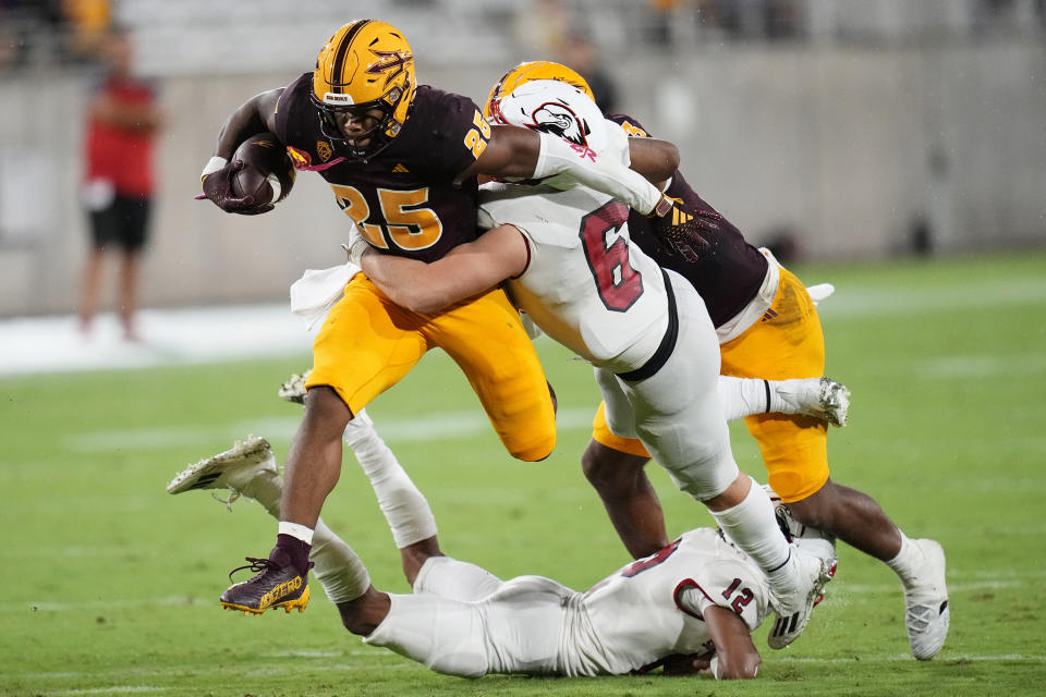 Southern Utah linebacker Kohner Cullimore (6) and Southern Utah safety Trevon Gola-Callard (12) upend a leaping Arizona State running back DeCarlos Brooks (25) during the second half of an NCAA college football game Friday, Sept. 1, 2023, in Tempe, Ariz. Arizona State won 24-21. (AP Photo/Ross D. Franklin)