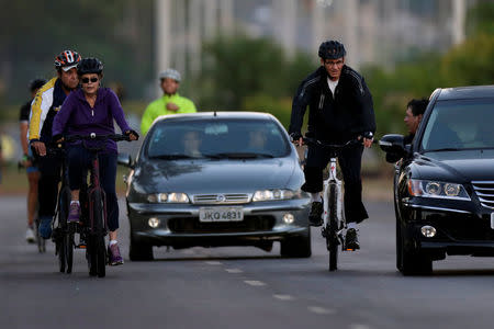 A man (unidentified) speaks with Brazil's President Dilma Rousseff as she rides her bicycle near the Alvorada Palace in Brasilia, Brazil April 15, 2016. REUTERS/Ueslei Marcelino