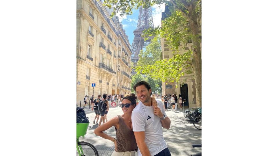 couple posing in front of eiffel tower