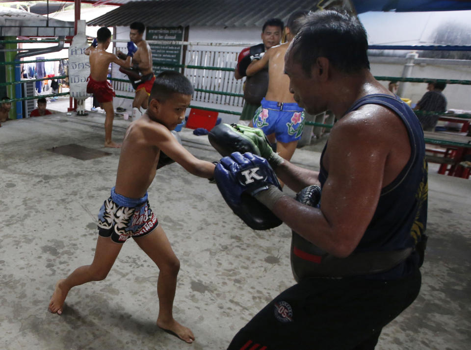 In this Wednesday, Nov. 14, 2018, photo, Thai kickboxer Chaichana Saengngern, 10-years old, spars at a training camp in Bangkok, Thailand. Thai lawmakers recently suggested barring children younger than 12 from competitive boxing, but boxing enthusiasts strongly oppose the change. They say the sport is part of Thai culture and gives poor families the opportunity to raise a champion that will lift their economic circumstances. (AP Photo/Sakchai Lalit)