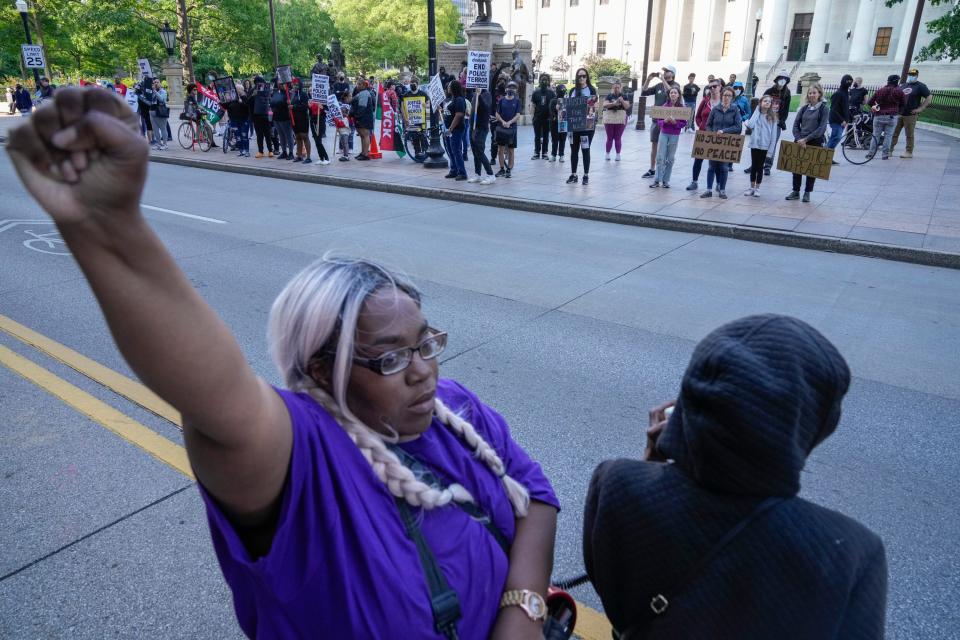 May 20, 2023; Columbus, Ohio, US;  Christina McDaniel, left, with the community group Wedgewood Unity, raises her fist while standing in South High Street during a protest for Sinzae Reed, a 13-year-old who was shot and killed in Columbus’ Hilltop neighborhood on Oct. 12, 2022 by Krieg Butler. A Franklin County grand jury recently declined to file murder charges for Butler. 